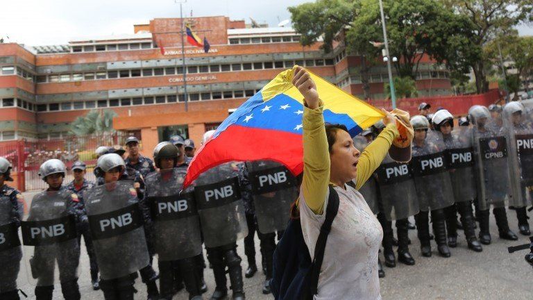 A woman waves a Venezuelan flag at a protest in Caracas