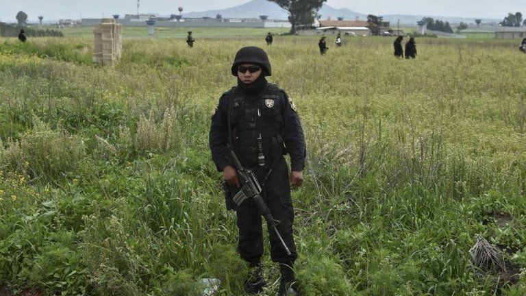 A federal police officer stands guard outside the house at the end of the tunnel through which Mexican drug lord Joaquin "El Chapo" Guzman escaped from on 12 July, 2015.