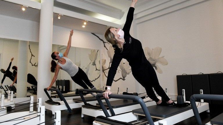 An instructor and gym member wear face masks as they take part in a pilates session at Fernwood Fitness Annadale gym, following 108 days of lockdown in Sydney, New South Wales, Australia, 11 October 2021