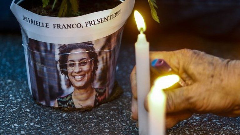 An elderly man lights a candle during a rally against the murder of Brazilian councilwoman and activist Marielle Franco, in Sao Paulo Brazil on March 15, 2018