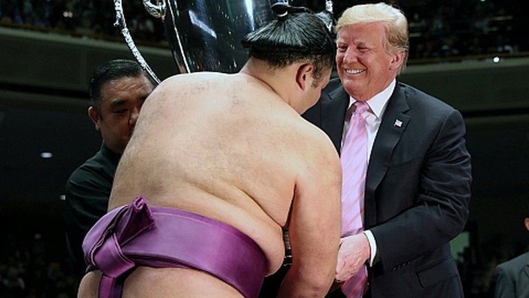 President Donald Trump presents the President's Cup to wrestler Asanoyama, winner of the Summer Grand Sumo Tournament at Ryogoku Kokigikan Sumo Hall in Tokyo, Japan May 26, 2019