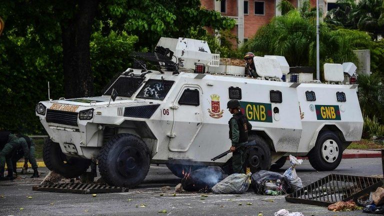 A National Guard vehicle goes through a barricade built by anti-government activists in Venezuela"s third city, Valencia, on August 6, 2016,