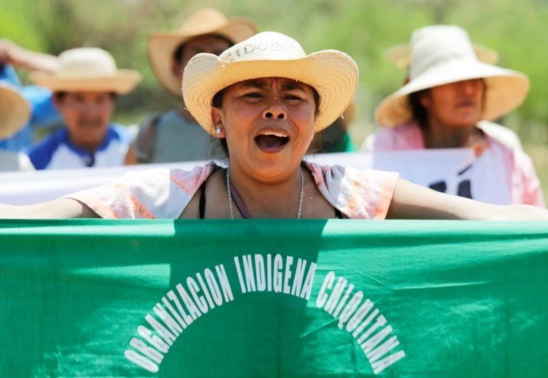 A woman shouts and holds up a banner reading Chiquitanía Indigenous Organisation during the protest march