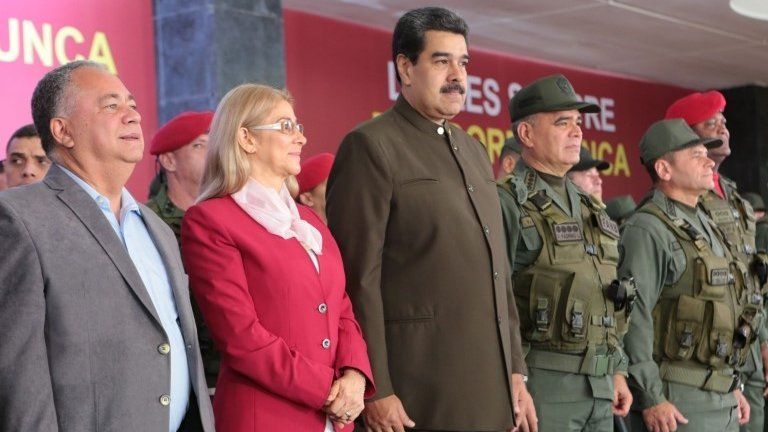 Handout photo released by Miraflores presidential press office showing Venezuela"s President Nicolas Maduro (C) flanked by his wife Cilia Flores (L) and Defense Minister Vladimir Padrino (R) during the 82nd anniversary ceremony of the Bolivarian National Guard at Military Academy, in Caracas on August 4, 2019