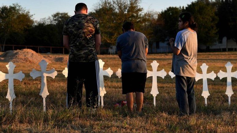 People pray at a row of crosses for each victim, following a mass shooting in Texas. Photo: 6 November 2017