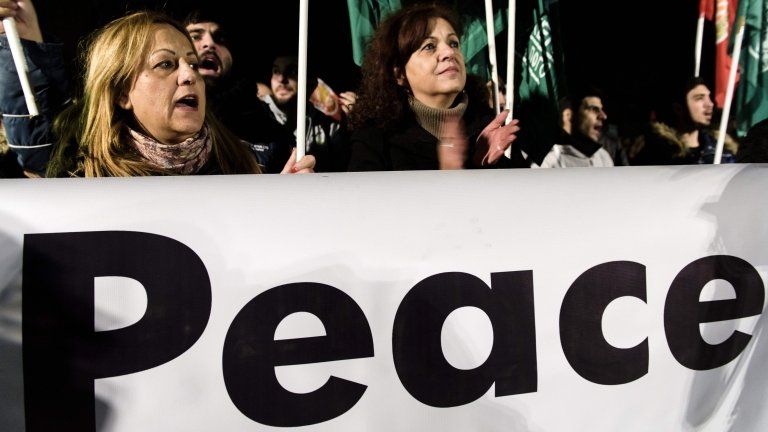 Greek Cypriots and Turkish Cypriots take part in a peace rally organised inside the UN-controlled buffer zone in Nicosia on January 10, 2017