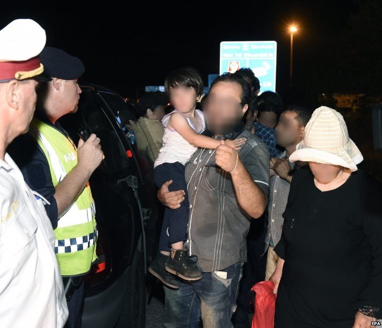 Nine adults and two children are detained by Austrian Police officers on patrol on the motorway near the Austro-Hungarian border, in Nickelsdorf, Austria (30 August 2015)
