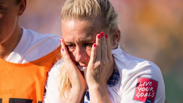 Laura Bassett of England is comforted by team-mates