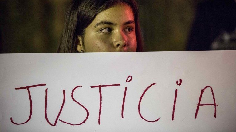 A woman holds a banner which reads: "JUSTICE" during a protest to honour the girls who lost their lives in a fire at a juvenile shelter in Guatemala