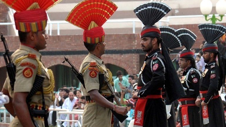 Pakistani Rangers, in black, and Indian Border Security Force (BSF) personnel perform on September 17,2014 the daily retreat ceremony at the India-Pakistan Border in Wagah