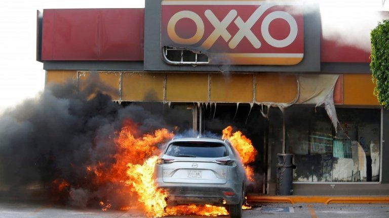 A burning car is pictured outside a store after an operation by security forces against organized crime in Celaya, in Guanajuato state, Mexico June 20, 2020.