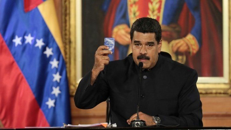 Venezuela's President Nicolas Maduro holds a copy of the Venezuelan constitution as he speaks during a ceremony at Miraflores Palace in Caracas, Venezuela May 1, 2017.