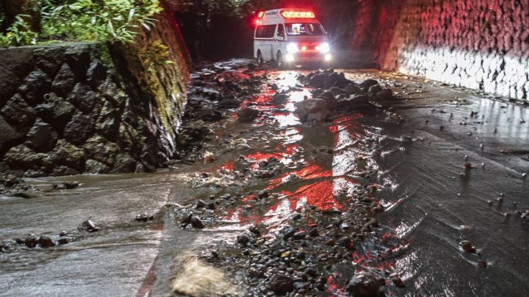 An emergency vehicle drives through debris on a flooded road during the evacuation of guests at the Osen Sanso Nakamura hotel in Sengokuhara, in Nakone province, Japan, 12 October 2019.