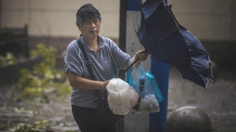 Woman struggles with umbrella in Shanghai