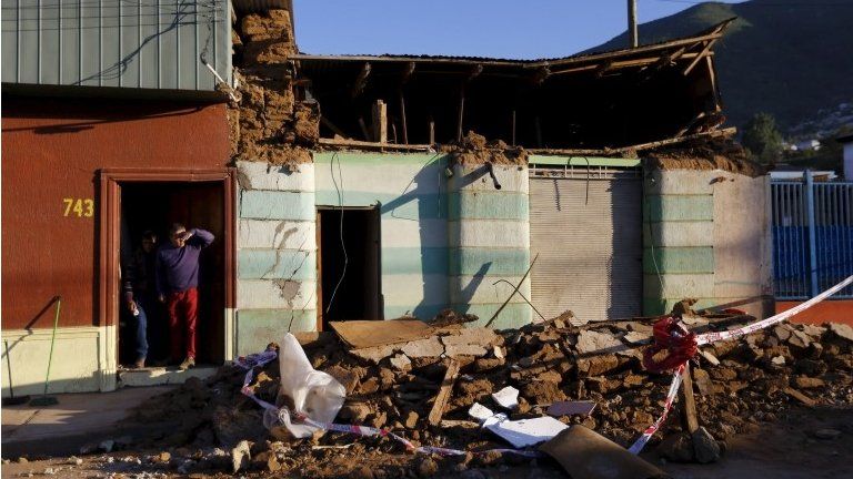 A resident looks on near debris of a damaged house after an earthquake hit areas of central Chile, in Illapel town, north of Santiago, Chile on 17 September, 2015