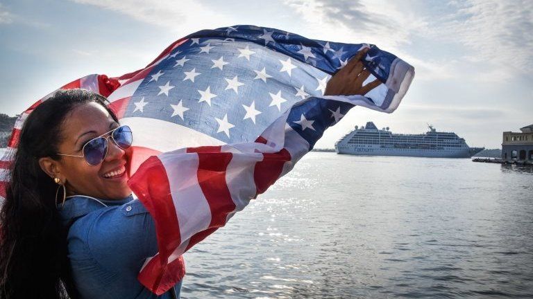A Cuban waves a US flag at the Malecon waterfront as the first US-to-Cuba cruise ship to arrive in the island nation in decades glides into the port of Havana, on May 2, 2016.