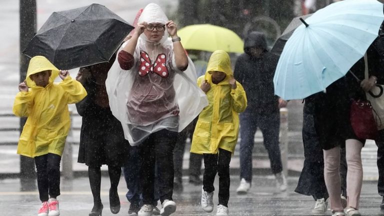 Pedestrians struggle against rain and wind in Tokyo, Japan, 12 October 2019