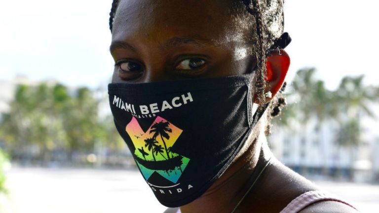 Mujer con mascarilla en Miami Beach.