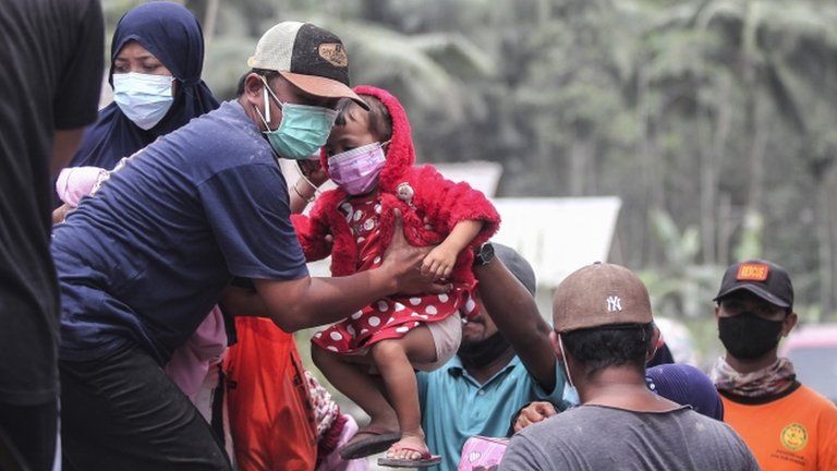Officials evacuate people from Kamar Kajang village in East Java to safer places after the eruption of Mt Semeru