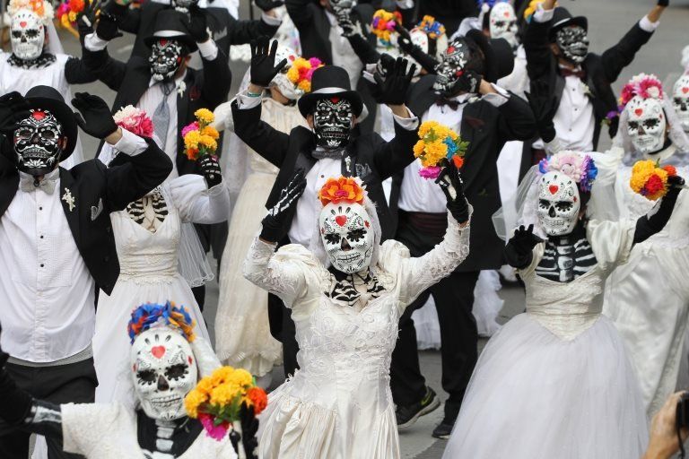 People dressed as skeletons dance during the Catrina parade in Mexico City on 27 October