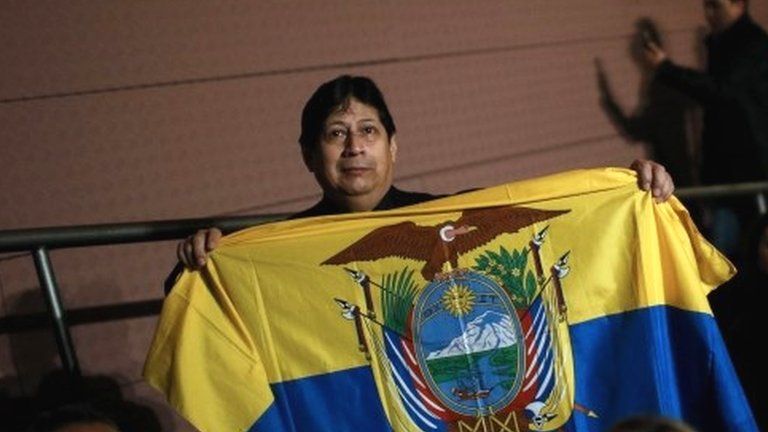 A man holds Ecuador"s flag as he waits for Ecuador"s President Rafael Correa to speak to Catalonia"s Ecuadorian community during an official visit to Barcelona on January 28, 2017