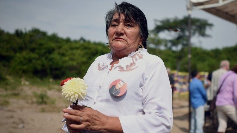A member of the Solecito group of relatives searching for their missing loved ones holds a flower at Colinas de Santa Fé in Mexico