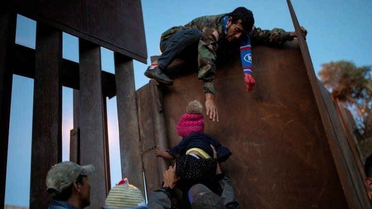 Migrants from Honduras try to jump a border fence in Tijuana, Mexico on 2 December, 2018