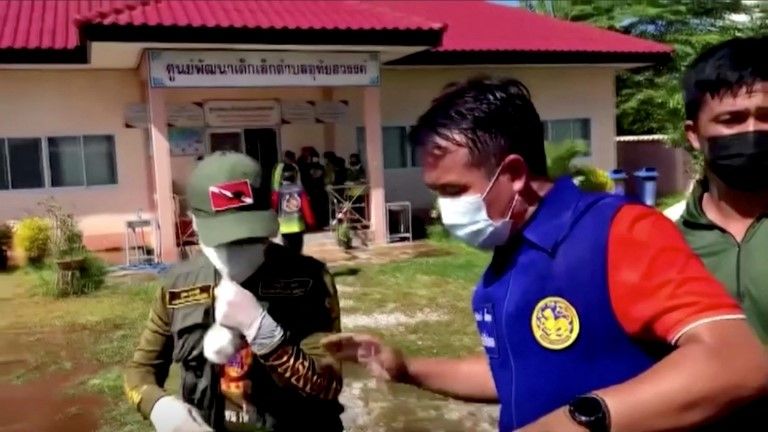 Officials and authorities guard the gate of daycare centre as people wait, after a mass shooting, in Uthai Sawan, Nong Bua Lamphu Province, Thailand