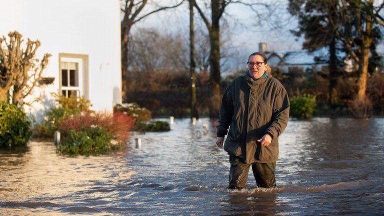 Gabrielle Burns-Smith outside her flooded home on the outskirts of Lymm in Cheshire