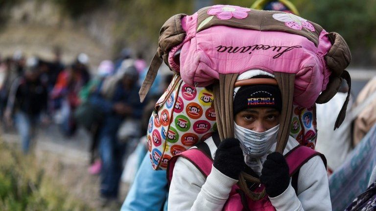 A Venezuelan migrant woman heading to Peru carries bags as she walks along the Panamerican highway in Tulcan, Ecuador, after crossing from Colombia, on August 21, 2018