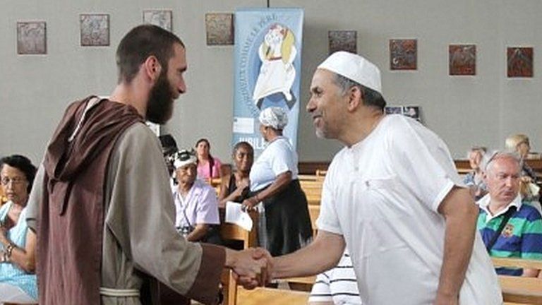 A catholic monk welcomes muslim worshippers in the Saint-Pierre-de-Ariane church before mass on 31 July 2016 in Nice