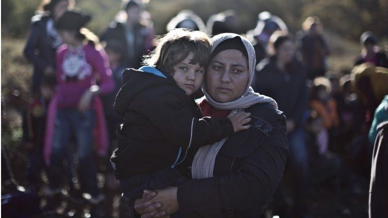 A Yazidi refugee woman from Iraq holds her child shortly after arriving on a vessel from the Turkish coast to the northeastern Greek island of Lesbos, Thursday, Nov. 26, 2015.