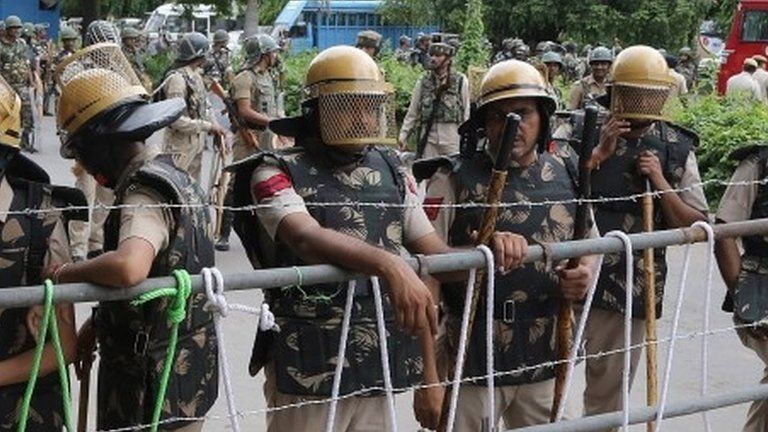 Indian security personel stand guard during riots by involving suspected Dera Sacha Sauda sect members in Panchkula, India, 25 August 2017.