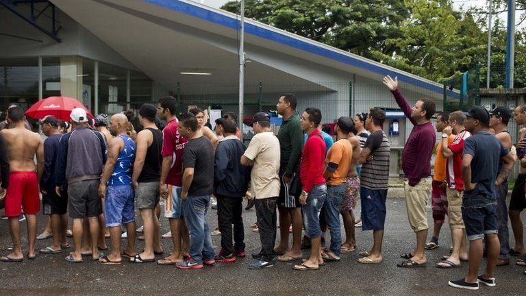 Cuban migrants line up for breakfast given to them by an evangelical church, outside of the border control building in Penas Blancas, Costa Rica, on 21 November 2015