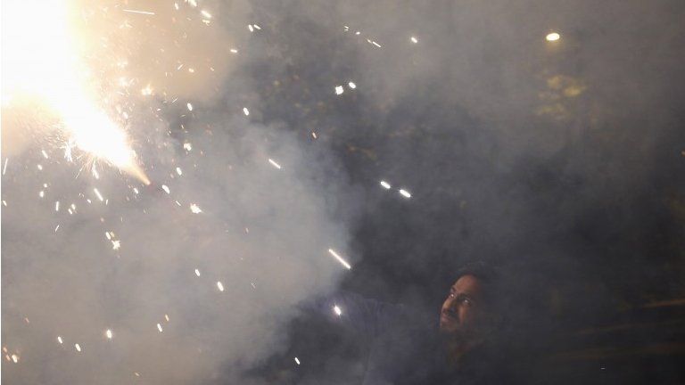 A man lights a firecracker while celebrating the Hindu festival of Diwali, the annual festival of lights in New Delhi, India, November 12, 2015.