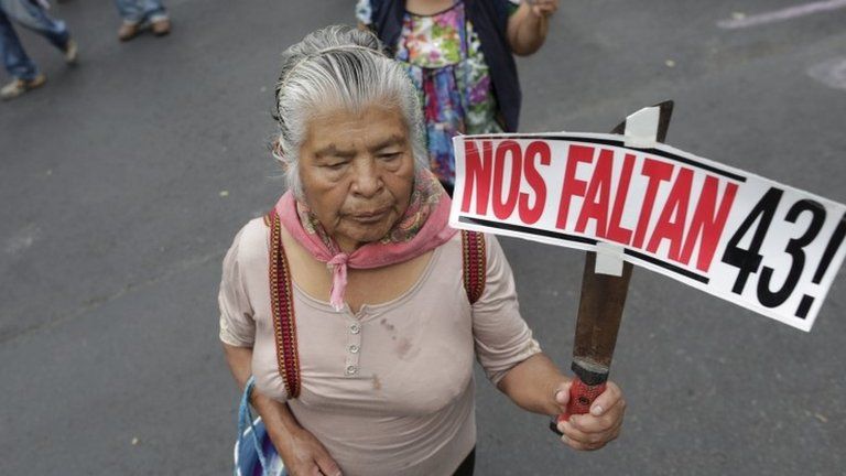 A demonstrator holds a sign as she takes part in a march in Mexico City to mark the disappearance of 43 students on 26 September, 2015.