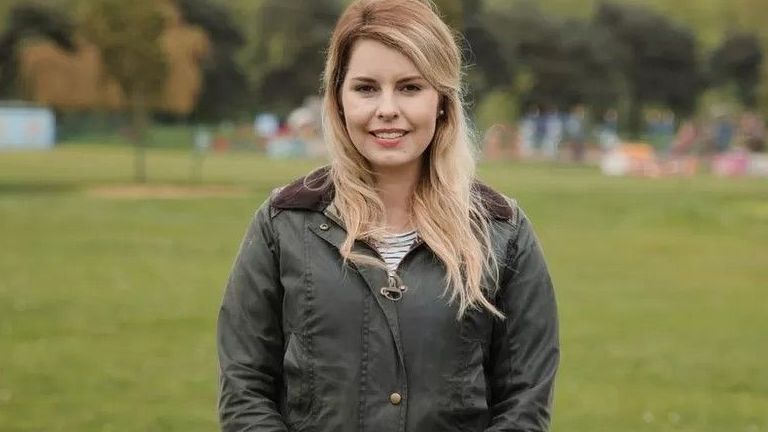 Kim McGuinness, who is blonde and wearing a Barbour jacket, standing on a field