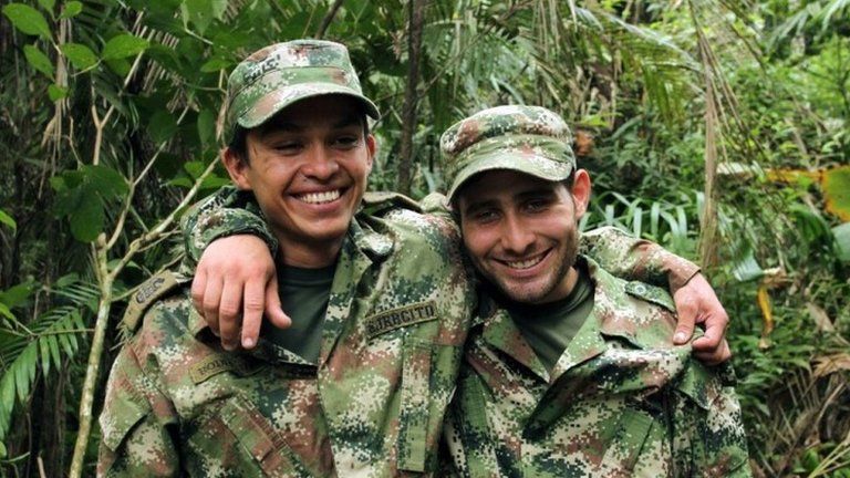 A handout photo released by Colombian Defensoria del Pueblo shows two Colombian soldiers Kleider Antonio Rodriguez (left) and Andres Felipe Perez posing after being released by the ELN guerrillas in Arauca, Colombia on 16 November 2015.