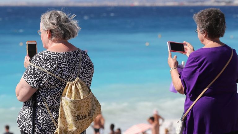 Två kvinnor använder sina mobiltelefoner i Frankrike