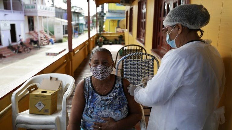 A health worker administers a Sinovac's CoronaVac coronavirus disease (COVID-19) vaccine to Luizete Soares da Silva, 66, outside her house in Anama, Amazonas state Brazil April 1, 2021. Picture taken April 1, 2021.