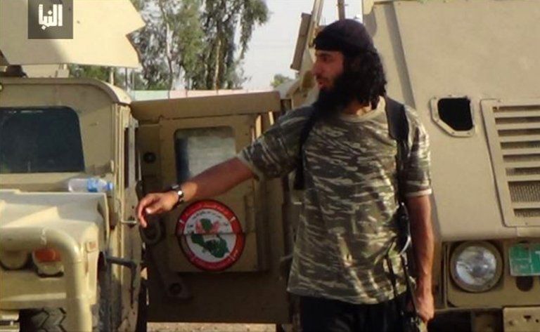Undated image of Jihadi John seen outside a vehicle in a camouflage shirt