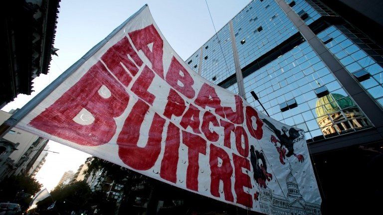 A banner that reads "Down the pact with vultures" is seen outside the Congress during a demonstration against the approval by lawmakers of a settlement with creditors over the country"s defaulted debt in Buenos Aires, Argentina, March 15, 2016.
