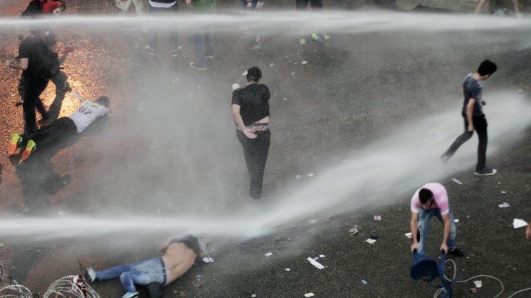 Lebanese activists are sprayed by riot police using water cannons in Beirut, 23 August 2015.