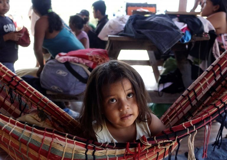 A girl rests in a hammock as her family sets up camp during the protest march.