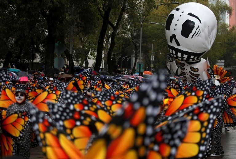 A balloon in the shape of a skeleton is pictured near participants dressed as Monarch butterflies during the annual Day of the Dead parade in Mexico City