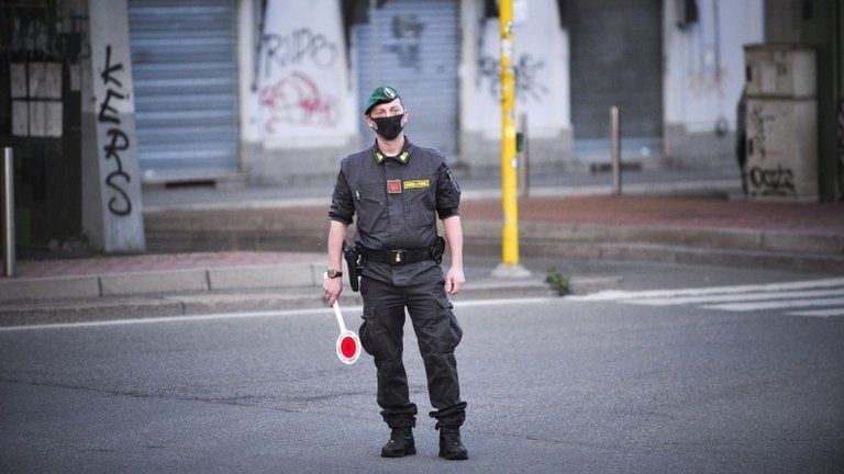 Italian Guardia di Finanza officers wearing protective face masks man a checkpoint between Corvetto and Rogoredo in Milan