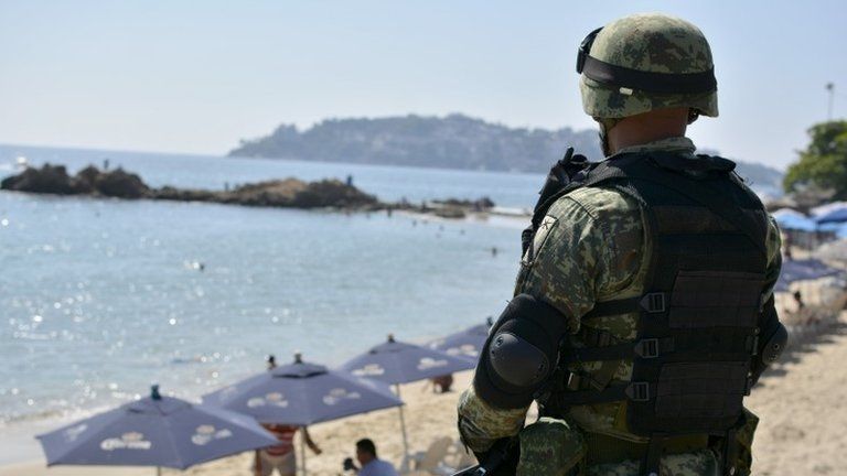 A Mexican Army soldier stands guard at a beach in Acapulco, Guerrero state, Mexico on December 5, 2017.