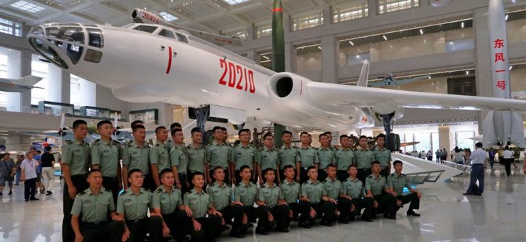Servicemen post in front of a H6-N strategic bomber