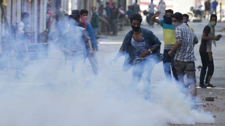 Kashmiri Muslim protesters are engulfed in tear gas smoke as they clash with Indian policemen in Srinagar, Indian controlled Kashmir, Monday, July 11, 2016.