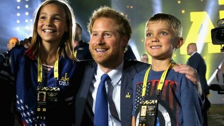 Prince Harry posing with children of servicemen and women at the opening ceremony of the Invictus Games